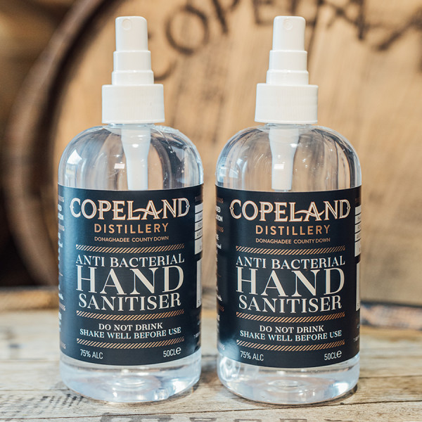 Two bottles of Copeland Distillery Hand Sanitiser sitting side by side with a Copeland Cask in the background